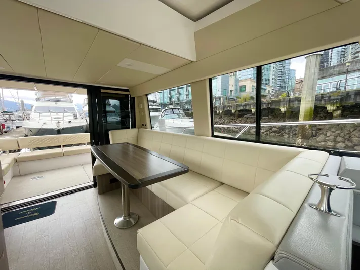 About Time Yacht Photos Pics Luxurious interior of 2022 Regal 42 Grande Coupe yacht with plush seating and large windows.