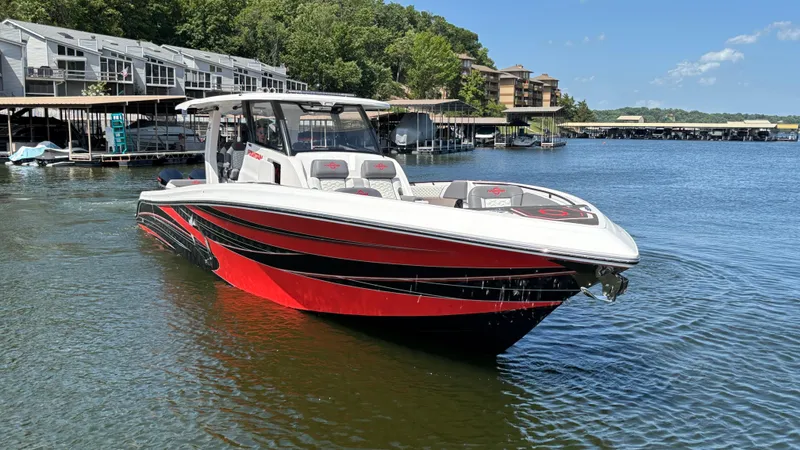  Yacht Photos Pics 2024 Fountain 43 SCX boat on a lake, featuring sleek red and black design.