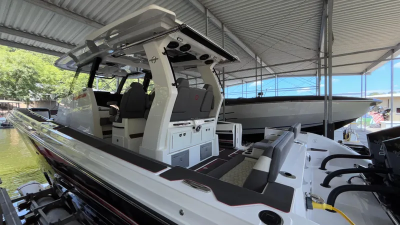  Yacht Photos Pics 2024 Fountain 43 SCX boat docked under a metal canopy.