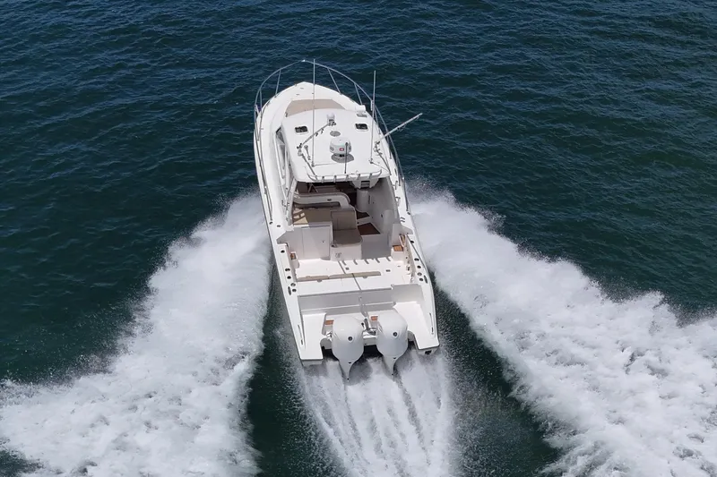 Cay Day Yacht Photos Pics 2017 Pursuit 325 OS boat cruising on open water, aerial view.