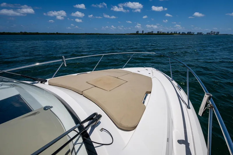 Cay Day Yacht Photos Pics 2017 Pursuit 325 OS boat deck with sun pad, ocean view, and clear blue sky.