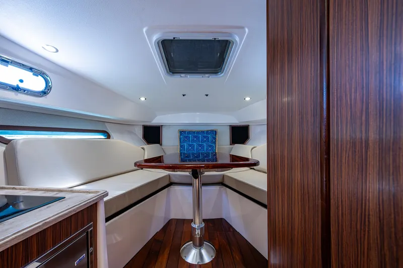 Cay Day Yacht Photos Pics 2017 Pursuit 325 OS cabin interior with seating and table.