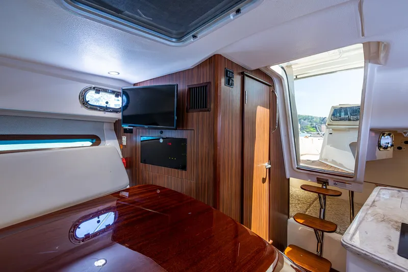 Cay Day Yacht Photos Pics Interior of 2017 Pursuit 325 OS boat with wood paneling and TV.
