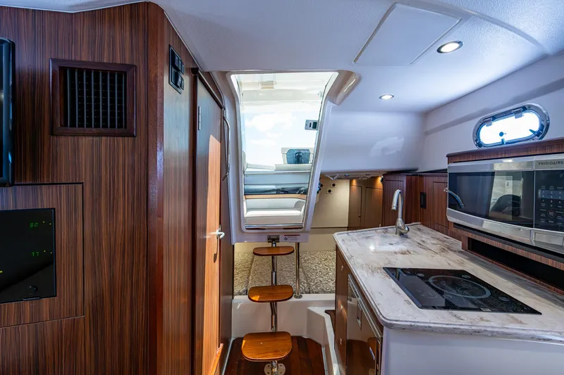 Cay Day Yacht Photos Pics Interior of 2017 Pursuit 325 OS boat with kitchen and seating area.