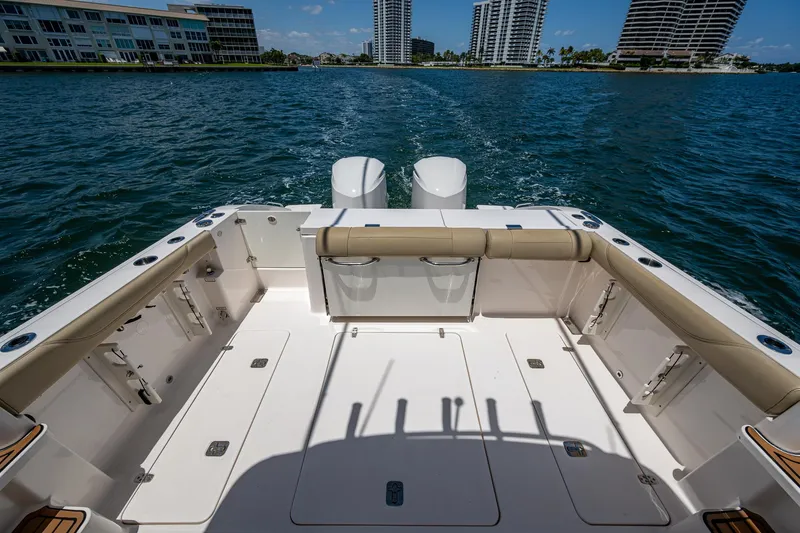 Cay Day Yacht Photos Pics 2017 Pursuit 325 OS boat deck with twin engines, overlooking waterfront cityscape.