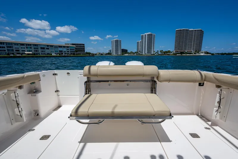 Cay Day Yacht Photos Pics 2017 Pursuit 325 OS boat with seating, overlooking waterfront cityscape.
