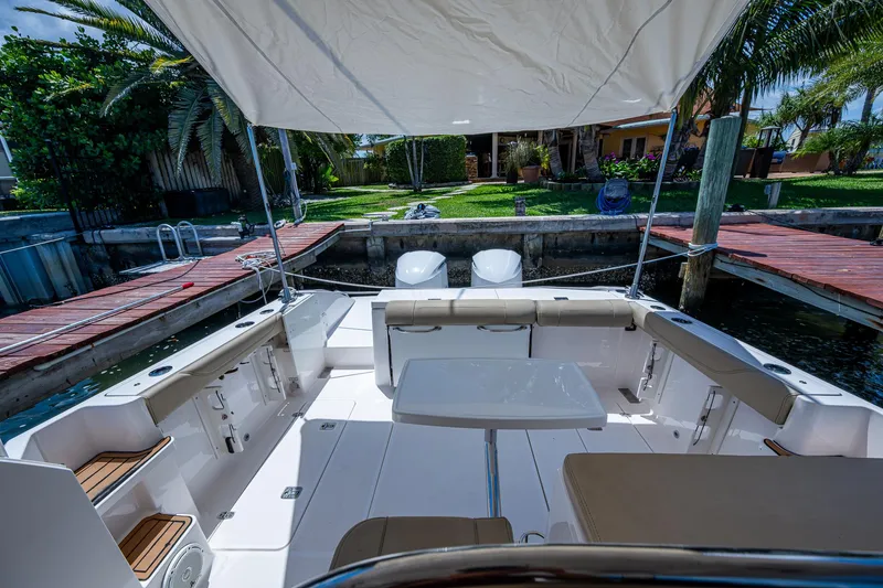 Cay Day Yacht Photos Pics 2017 Pursuit 325 OS boat interior with seating, table, and canopy in a dock setting.