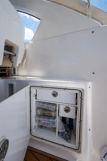 Cay Day Yacht Photos Pics 2017 Pursuit 325 OS boat storage compartment with organized shelves and clear sky view.