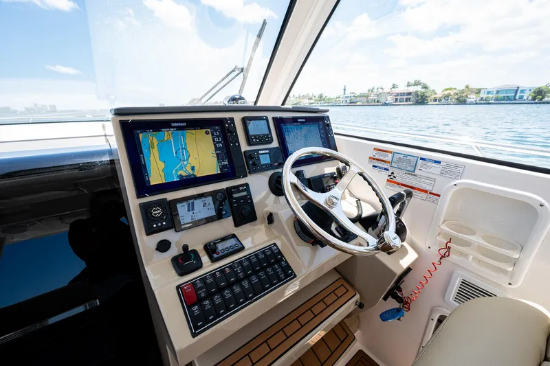 Cay Day Yacht Photos Pics 2017 Pursuit 325 OS boat helm with navigation screens and steering wheel.