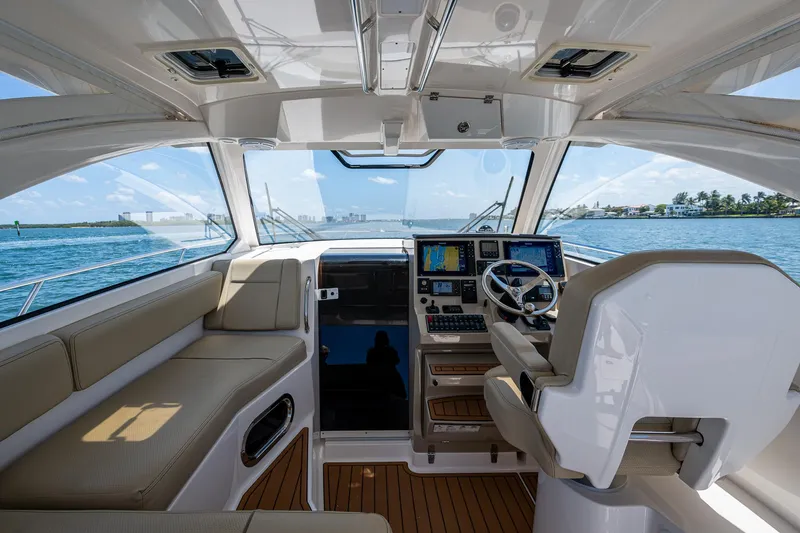 Cay Day Yacht Photos Pics Interior of 2017 Pursuit 325 OS boat with modern helm and seating, overlooking ocean.