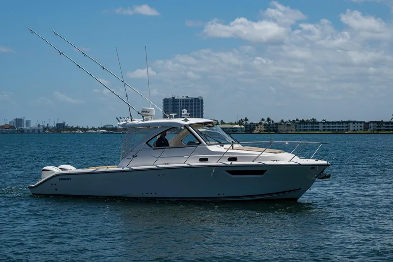 Cay Day Yacht Photos Pics 2017 Pursuit 325 OS boat on calm water under a partly cloudy sky.
