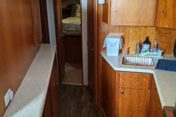 Yacht Photos Pics 2001 Silverton 42 Convertible yacht interior with wood cabinetry and compact kitchen area.