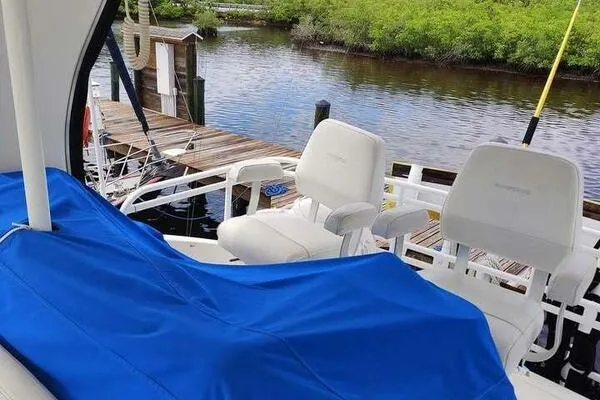  Yacht Photos Pics 2001 Silverton 42 Convertible boat interior with blue cover and white seats by a dock.