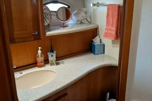  Yacht Photos Pics 2001 Silverton 42 Convertible yacht bathroom with wooden cabinetry and modern fixtures.