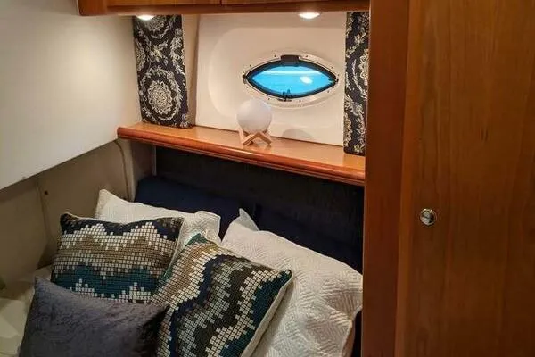  Yacht Photos Pics Cozy cabin interior of 2001 Silverton 42 Convertible yacht with decorative pillows and porthole.
