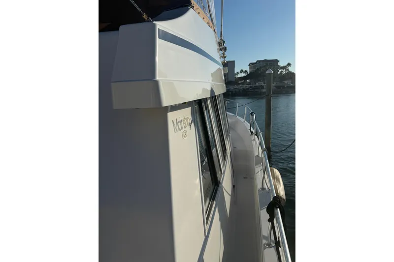 Jomallie Yacht Photos Pics 1999 Mainship 430 Trawler docked, side view with railing and windows.