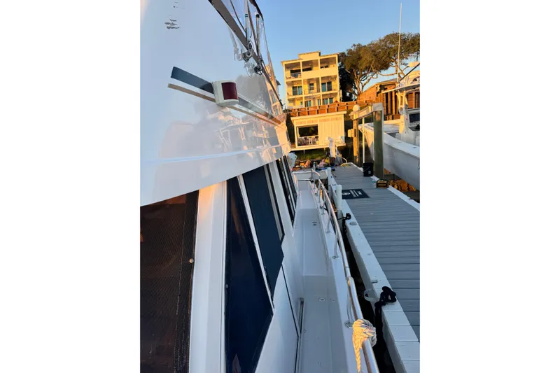 Jomallie Yacht Photos Pics 1999 Mainship 430 Trawler docked at marina during sunset.