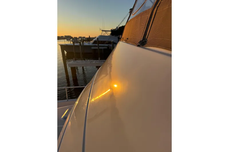 Jomallie Yacht Photos Pics 1999 Mainship 430 Trawler reflecting sunset on calm waters at a marina.