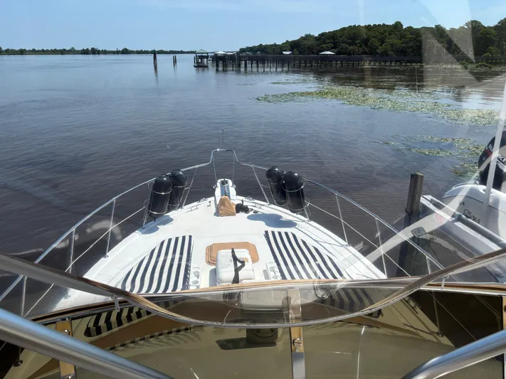 Adagio Yacht Photos Pics 2005 Jefferson Rivanna 50 SDMY yacht on calm water, docked near a wooded shoreline.