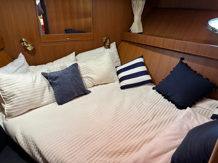 Adagio Yacht Photos Pics Cozy cabin bedroom in 2005 Jefferson Rivanna 50 SDMY yacht with plush pillows and wood paneling.