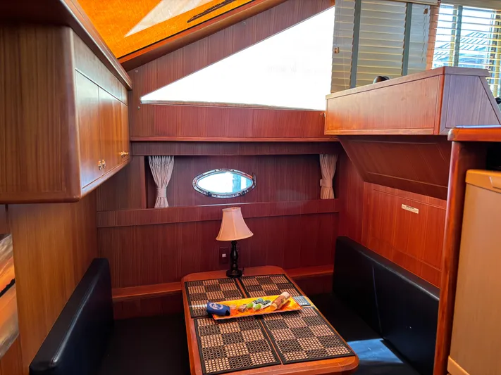 Adagio Yacht Photos Pics Interior of 2005 Jefferson Rivanna 50 SDMY yacht with wooden finishes and dining area.