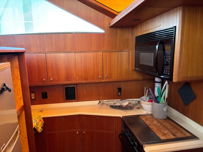 Adagio Yacht Photos Pics 2005 Jefferson Rivanna 50 SDMY yacht kitchen with wood cabinetry and modern appliances.