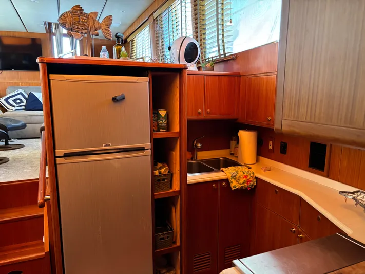 Adagio Yacht Photos Pics 2005 Jefferson Rivanna 50 SDMY yacht interior with kitchen, fridge, and wooden cabinetry.