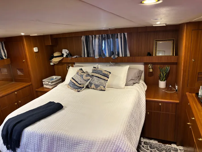 Adagio Yacht Photos Pics Luxurious bedroom interior of 2005 Jefferson Rivanna 50 SDMY yacht with cozy bedding and wood accents.