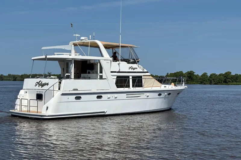 Adagio Yacht Photos Pics 2005 Jefferson Rivanna 50 SDMY yacht cruising on a calm river under a clear blue sky.