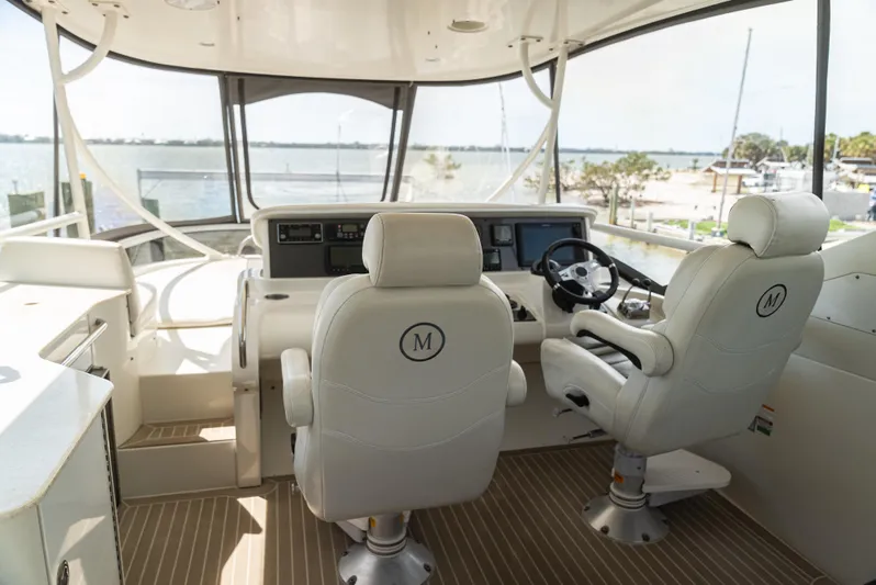  Yacht Photos Pics Interior helm of 2008 Marquis 50 LS yacht with dual captain chairs and navigation controls.