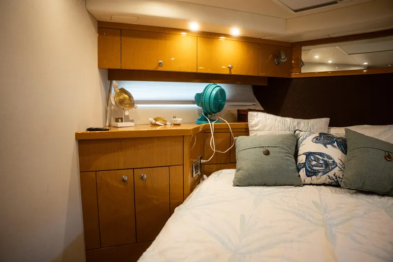  Yacht Photos Pics Cozy bedroom interior of 2008 Marquis 50 LS yacht with wooden cabinets and decorative pillows.