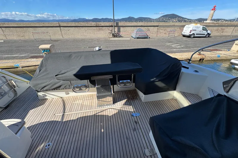 Yacht Photos Pics 2020 Monte Carlo 52 yacht deck with covered seating and scenic harbor view.