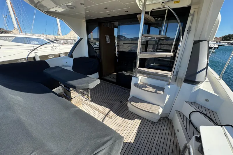  Yacht Photos Pics Luxurious 2020 Monte Carlo 52 yacht interior with spiral staircase and seating area.