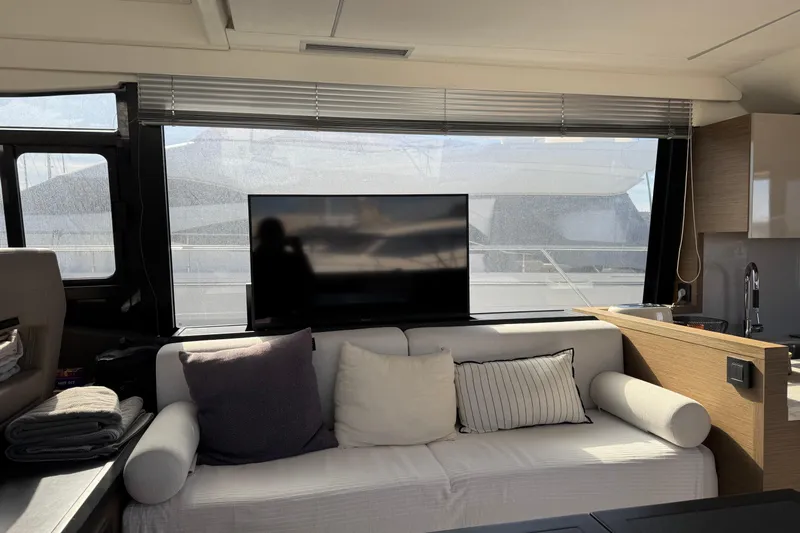  Yacht Photos Pics Interior of 2020 Monte Carlo 52 yacht with sofa, TV, and large window.