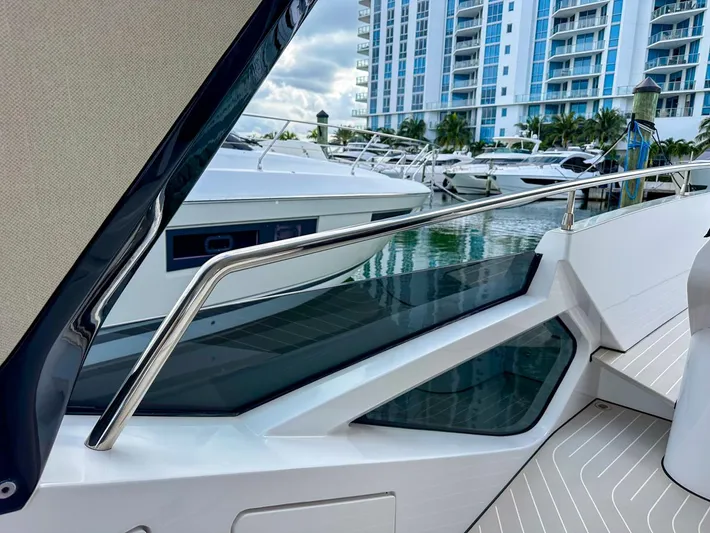  Yacht Photos Pics 2023 Azimut Verve 47 yacht docked near modern waterfront buildings.