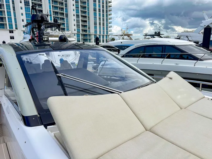  Yacht Photos Pics 2023 Azimut Verve 47 yacht with sunbathing area, docked near modern buildings.