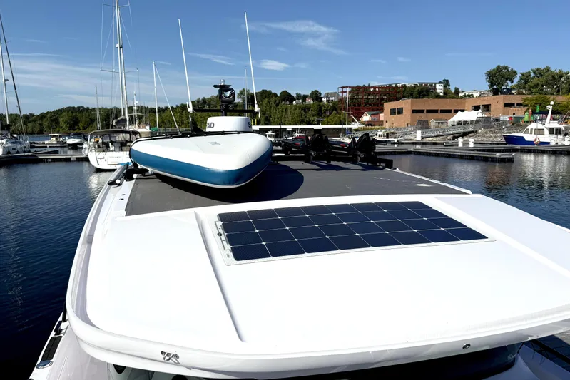  Yacht Photos Pics 2025 Axopar 37 XC CROSS CABIN with solar panel, docked in a marina under clear skies.