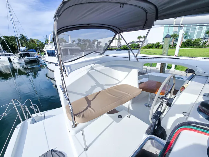 Breathing Room Yacht Photos Pics 2014 Fountaine Pajot Lipari 41 catamaran helm with canopy, docked in a marina.