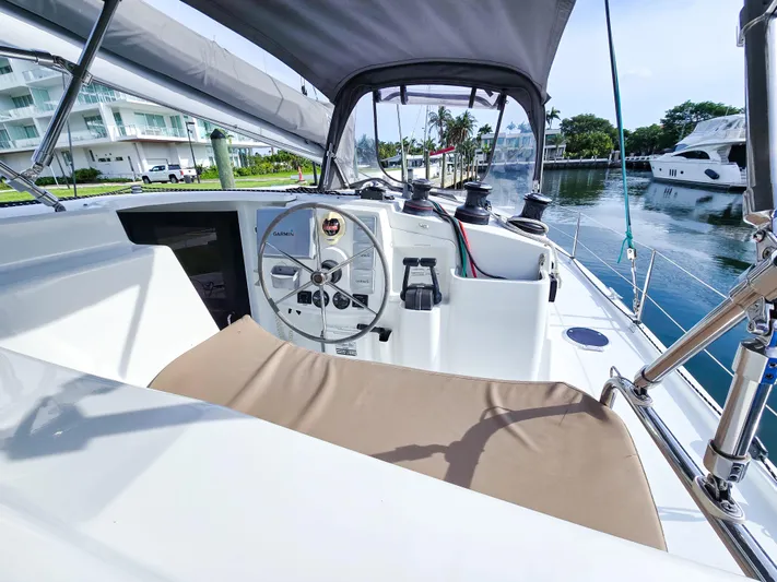 Breathing Room Yacht Photos Pics 2014 Fountaine Pajot Lipari 41 catamaran cockpit with steering wheel, docked near luxury yachts.