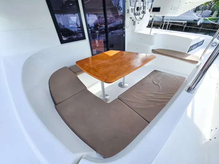 Breathing Room Yacht Photos Pics 2014 Fountaine Pajot Lipari 41 catamaran cockpit with cushioned seating and wooden table.