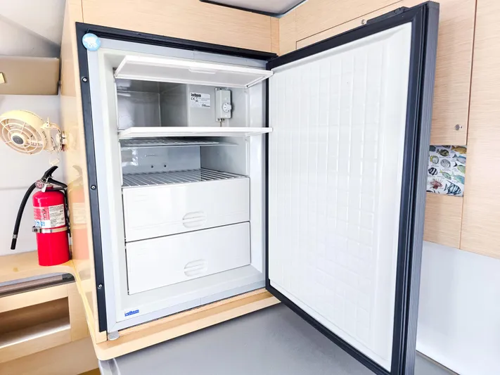 Breathing Room Yacht Photos Pics Open refrigerator inside 2014 Fountaine Pajot Lipari 41 catamaran, with fire extinguisher nearby.