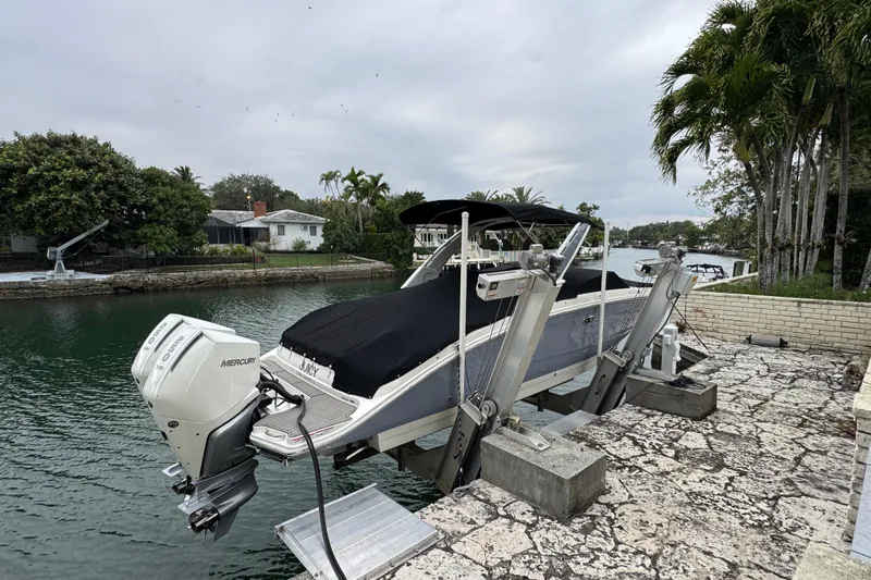  Yacht Photos Pics 2025 Sea Ray SDX 290 Outboard boat on lift by waterfront, covered and docked.