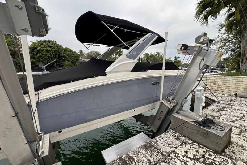  Yacht Photos Pics 2025 Sea Ray SDX 290 Outboard boat on lift, covered and docked by water.