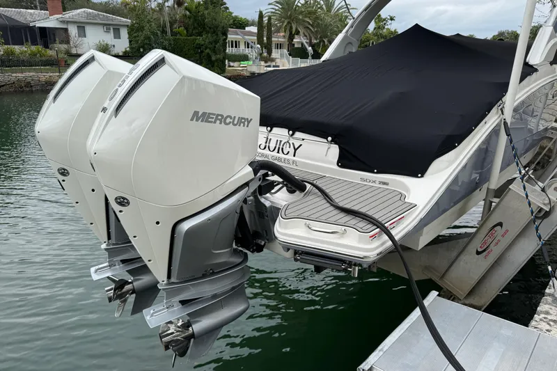  Yacht Photos Pics 2025 Sea Ray SDX 290 Outboard with dual Mercury engines docked by waterfront homes.