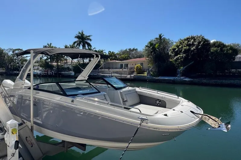  Yacht Photos Pics 2025 Sea Ray SDX 290 Outboard boat docked by a scenic waterfront.