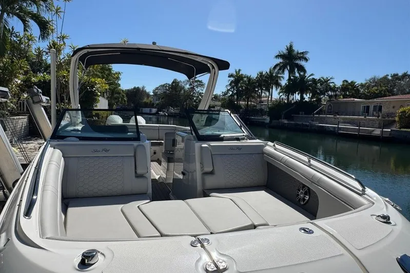  Yacht Photos Pics 2025 Sea Ray SDX 290 Outboard boat with luxurious seating, docked by a scenic canal.