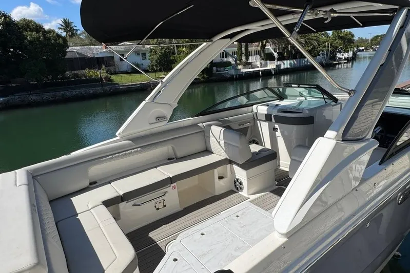  Yacht Photos Pics 2025 Sea Ray SDX 290 Outboard boat interior with seating and helm, docked by a canal.