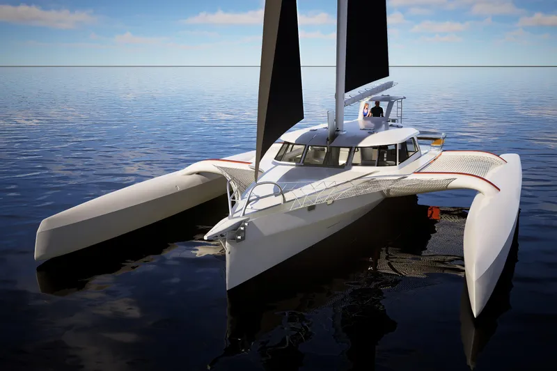  Yacht Photos Pics 2026 Rapido 63 trimaran sailing on calm ocean waters under a clear sky.