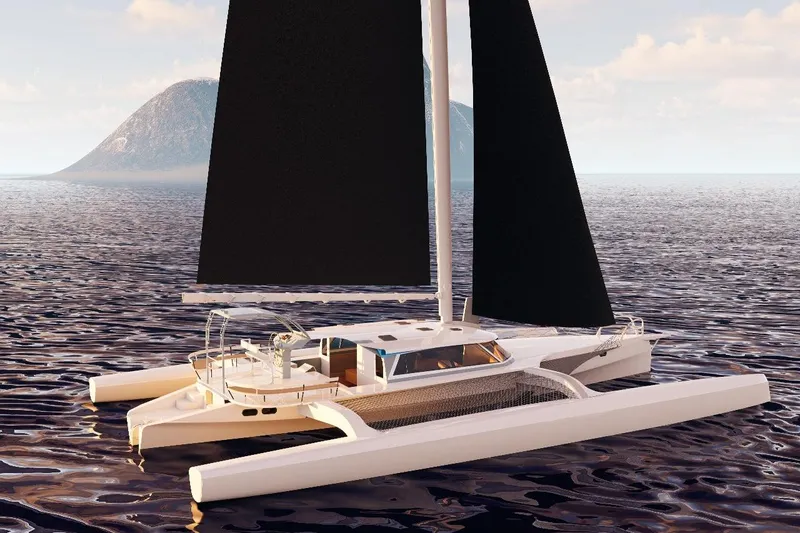  Yacht Photos Pics 2026 Rapido 63 trimaran sailing on calm ocean with distant island backdrop.