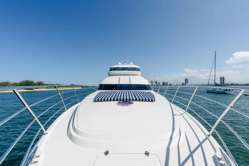 Infinite Yacht Photos Pics 1999 Warren Yachts 85 Motor Yacht cruising on a sunny day, with city skyline in background.